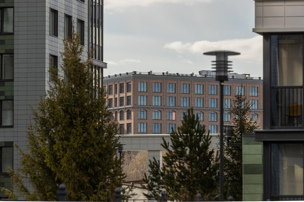 Vue d'un bâtiment en brique au loin à travers des parties des murs des maisons voisines avec un lam