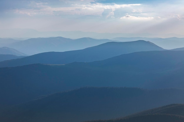 Vue bleue panoramique des collines et des prés de montagne pendant le coucher du soleil