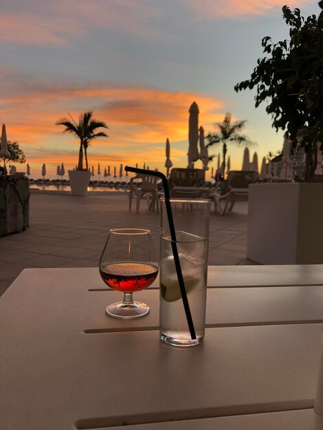 Photo vue d'une boisson sur la table au coucher du soleil