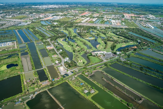 La vue sur le champ vert et la ferme et le centre-ville de la ville au milieu de la Thaïlande. Il a tiré de Jetplane.