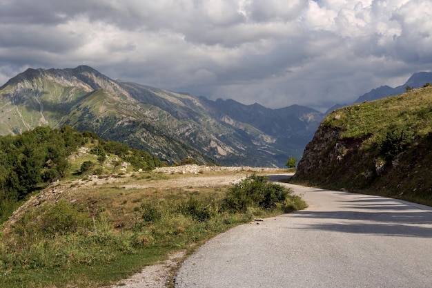 Vue d'un chemin rural et des montagnes dans une région de soirée nuageuse estivale Tzoumerka Grèce montagnes Pindos