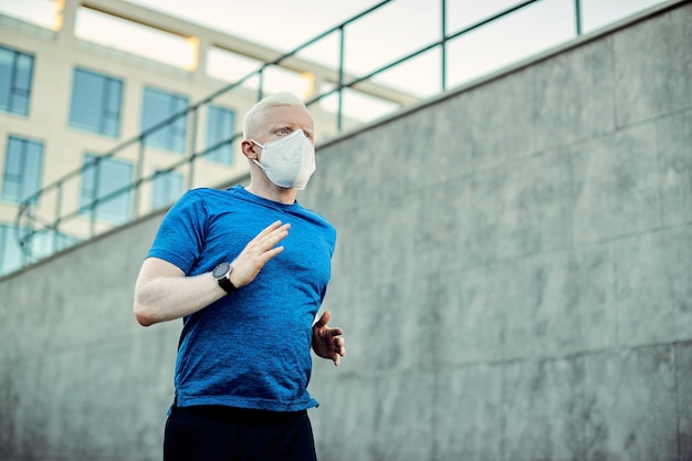 Vue ci-dessous d'un athlète albinos avec masque protecteur courant dans la ville