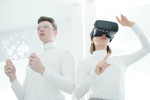 Vue ci-dessous de jeunes développeurs synchronisant un simulateur de réalité virtuelle et une tablette futuriste