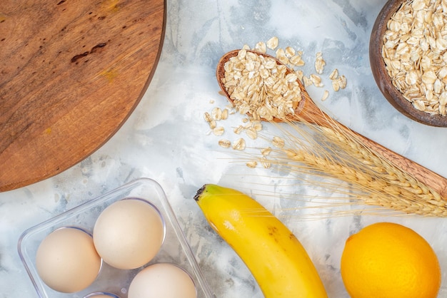 Vue Ci-dessus D'une Planche Ronde En Bois Et D'ingrédients Pour L'ensemble D'aliments Sains Sur Une Table Blanche Tachée