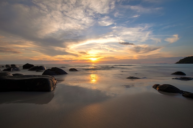 Vue d&#39;un ciel d&#39;or au coucher du soleil avec des vagues qui s&#39;écrasent sur la mer