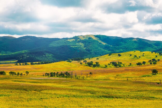 Photo vue de collines colorées et ciel nuageux