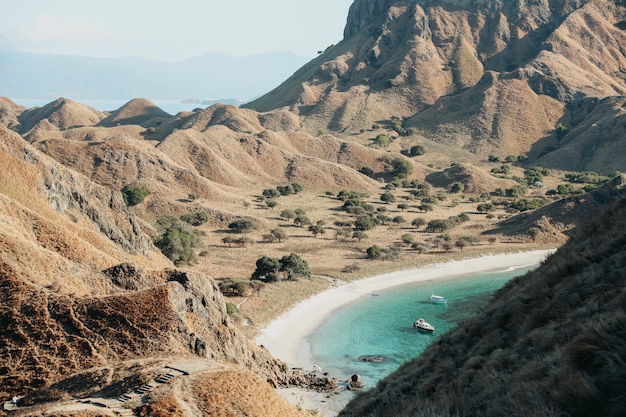 Vue sur les collines de la savane sur l'île de Padar avec côte et bateau