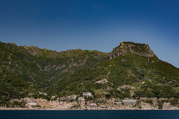 Vue sur la côte amalfitaine depuis la mer Vue sur les rochers, les montagnes verdoyantes et les petites villes depuis le bateau