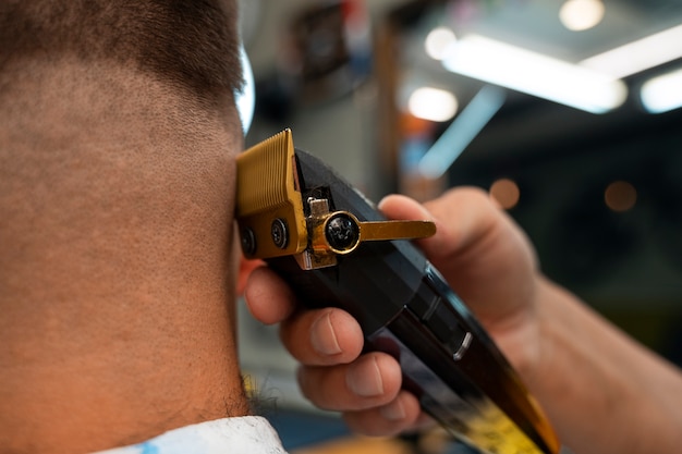 Photo vue de côté homme se faire couper les cheveux