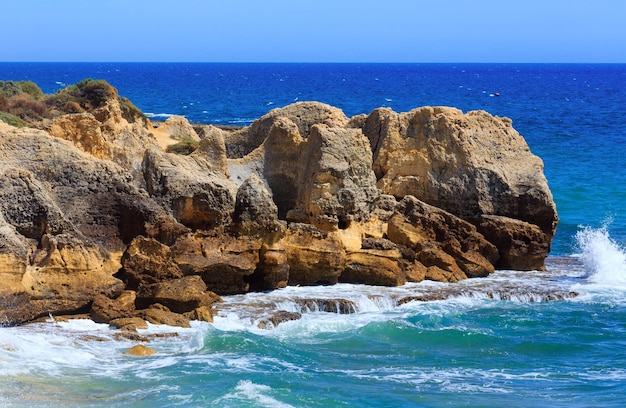 Vue de la côte rocheuse de l'Atlantique d'été avec des éclaboussures de vagues (périphérie d'Albufeira, Algarve, Portugal).