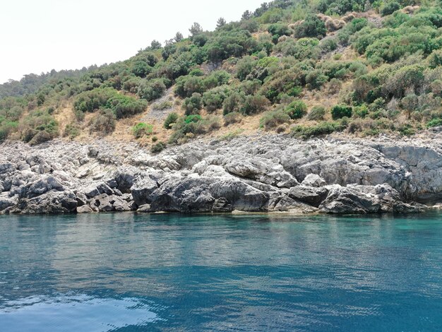 Vue sur la côte rocheuse de la mer Égée bleue depuis l'eau. Turquie, Kusadası