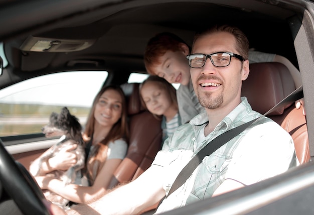 Vue de côtépère heureux au volant d'une voiture familiale