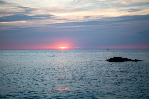 Vue sur le coucher de soleil au-dessus du yacht de mer en arrière-plan