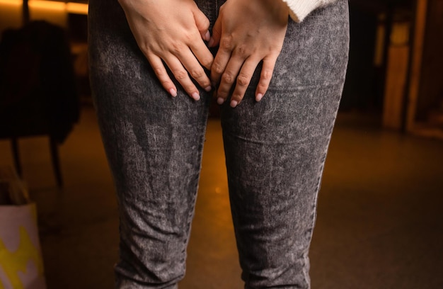 Vue en coupe basse des jeans mouillés de la personne debout sur un tapis