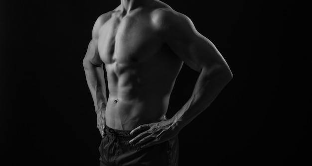 vue coupée d'un homme avec des abdominaux musclés en studio un homme avec des abs musculaires sur un fond noir