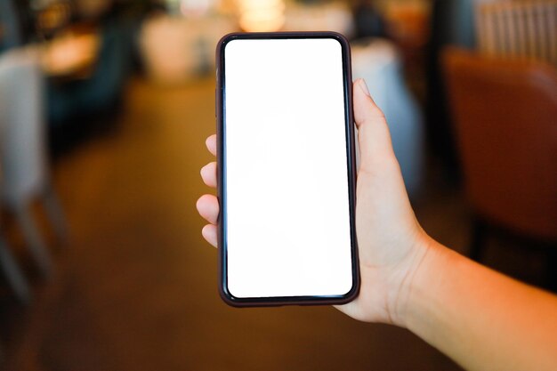 Vue coupée des mains des femmes tenant un téléphone portable copie blanche écran spatial téléphone intelligent avec concept de technologie