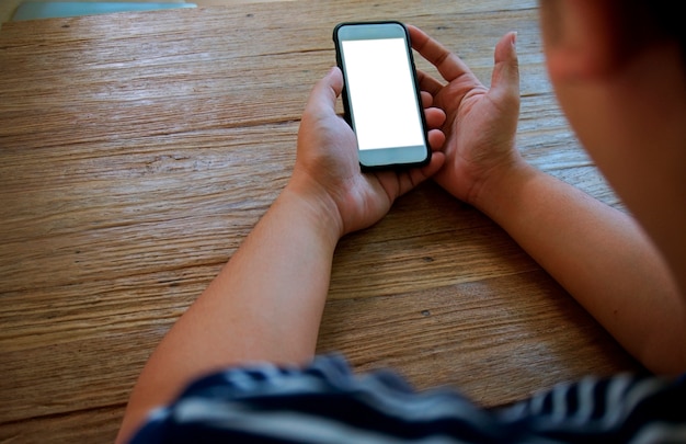 Vue croisée des mains masculines tenant le téléphone portable avec un écran vierge. Utiliser un gadget électronique, taper un message ou vérifier le flux de nouvelles sur les réseaux sociaux.