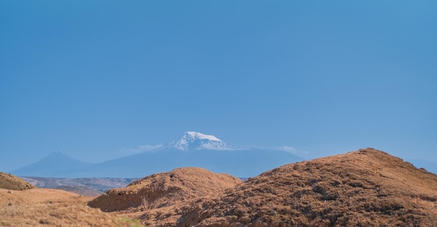 Vue depuis la colline d'Arin Berd et la forteresse d'Erebuni jusqu'au sommet majestueux de l'Ararat enneigé Voyager dans des lieux populaires du patrimoine de l'idée de l'histoire humaine pour une bannière ou une carte postale