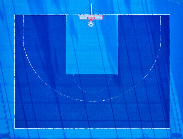 Vue depuis le drone sur le terrain de basket avec revêtement bleu, gazon artificiel.