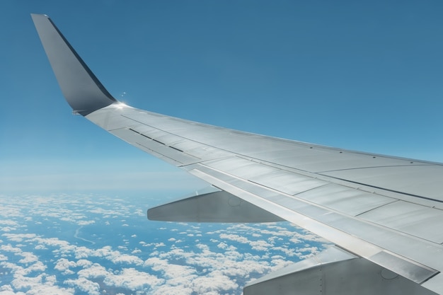 Vue depuis la fenêtre de l'avion sur une aile d'avion et un ciel avec des nuages