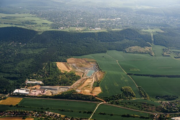 Vue depuis la fenêtre de l'avion sur les plaines verdoyantes et les collines boisées de Budapest