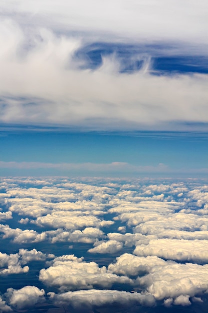 Vue depuis une fenêtre d'avion, volant au-dessus des nuages blancs