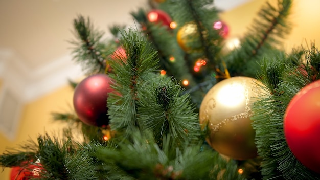 Vue Depuis Le Sol Sur Un Magnifique Sapin De Noël Décoré Avec Des Lumières Rougeoyantes Et Des Boules étincelantes. Arrière-plan Abstrait Parfait Pour Les Vacances D'hiver Ou Les Célébrations