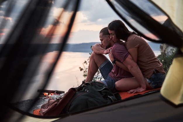 Vue depuis la tente d'un couple allongé sur le lac lors d'une randonnée. avel Lifestyle concept aventure vacances en plein air