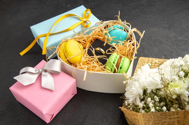 vue de dessous boîte en forme de coeur avec bague de fiançailles macarons coffrets cadeaux roses bleu bouquet de fleurs sur fond sombre