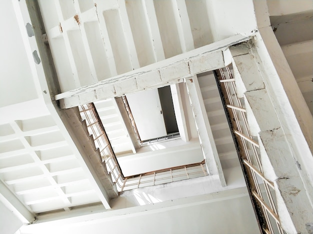 Vue de dessous de la cage d'escalier d'un immeuble de grande hauteur