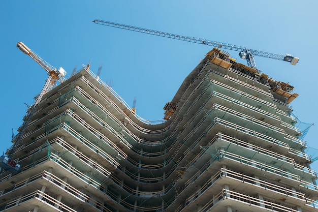 Vue de dessous sur la construction de gratte-ciel sur fond de ciel bleu