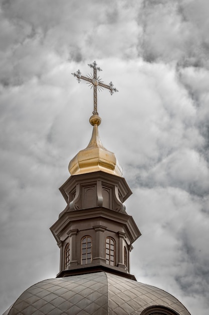 Vue de dessous du dôme de l'église avec une croix contre un ciel nuageux ciel biblique