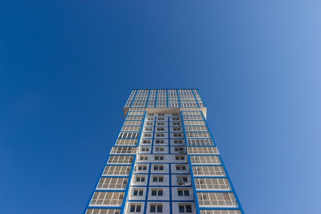 Vue de dessous de la façade d'un immeuble résidentiel élevé contre un ciel bleu