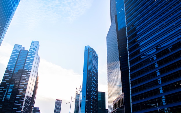 Photo vue de dessous des gratte-ciel modernes / immeubles de bureaux dans le quartier des affaires des villes de singapour contre le ciel bleu. économie, finances, concept d'activité commerciale. copiez l'espace pour le contenu.