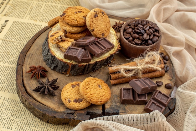 vue de dessous planche rustique en bois avec bol à biscuits avec grains de café torréfiés bol de cacao au chocolat bâtons de cannelle sur table