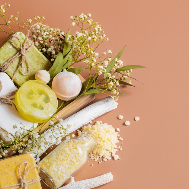 Vue de dessus des accessoires de spa et de soins du corps dans une boîte en bois sur un mur coloré