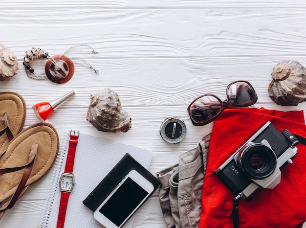 Vue de dessus des accessoires de voyage féminins sur fond bleu en bois avec copie