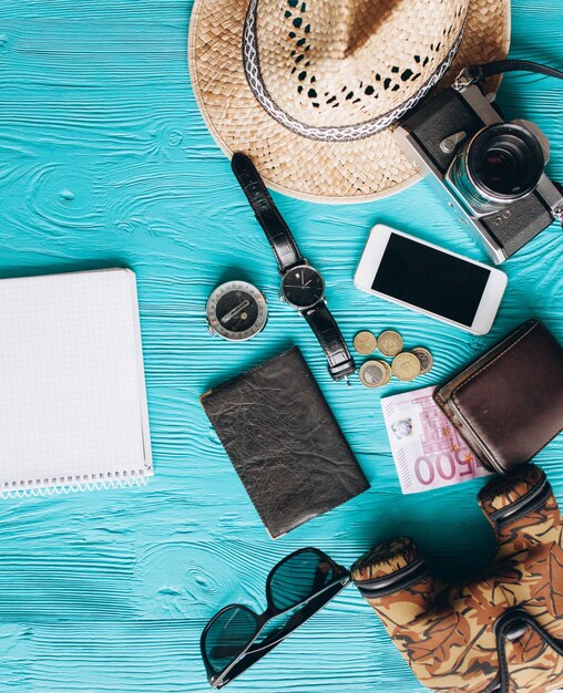 Vue de dessus des accessoires de voyage sur fond bleu en bois avec copie