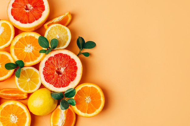 Vue de dessus des agrumes de pamplemousse orange et de citron avec des herbes sur fond jaune