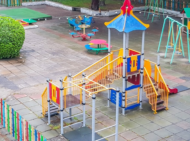 Vue de dessus d'une aire de jeux pour enfants colorée et vide dans un parc public, balançoires sûres, toboggans.