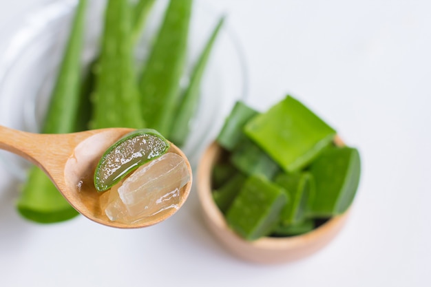 Vue de dessus d&#39;aloe vera en tranches et feuilles sur la cuillère en bois et un bol