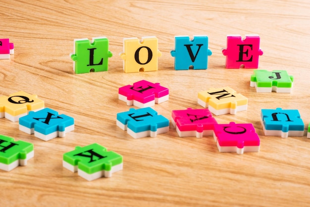 Vue de dessus alphabet d'apprentissage avec puzzle dans le tableau Mot d'amour du puzzle Espace de copie Apprentissage sous la forme d'un concept de jeu Apprentissage facile Niveau d'étude