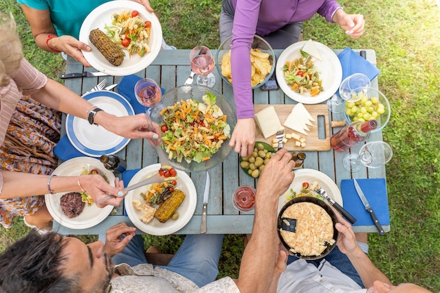 Vue de dessus d'amis assis à une table en bois en train de dîner