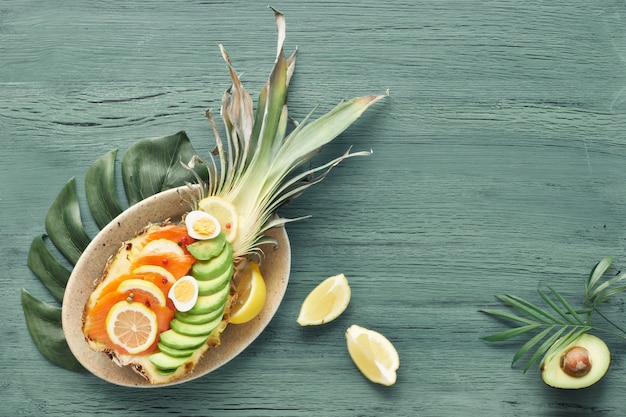 Vue de dessus sur ananas avec saumon fumé, avocat, citron et oeufs de caille, copy-space