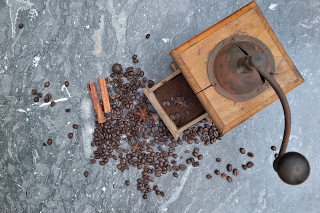 Vue De Dessus Sur L'ancien Moulin à Café Plein De Café Et De Grains Avec Des épices Sur Fond De Marbre Gris