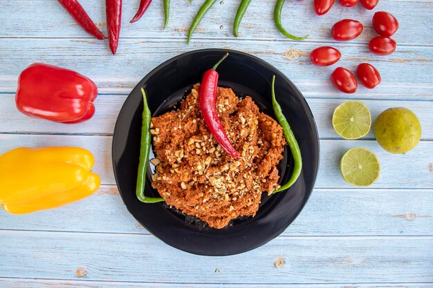 Vue de dessus des apéritifs muhammara sur fond de bois bleu