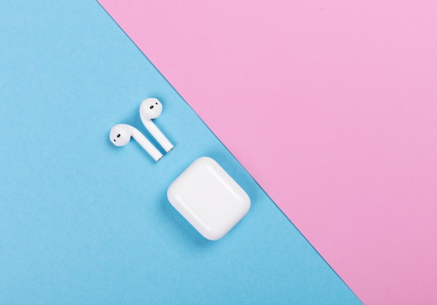 Vue de dessus des Apple AirPods sur fond rose et bleu