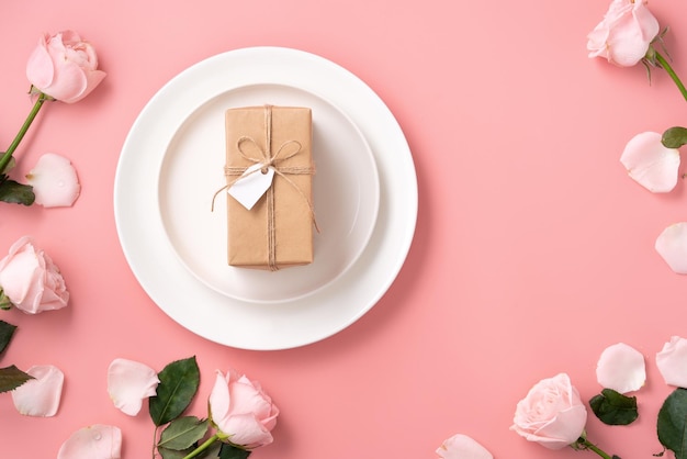Vue de dessus de l'arrière-plan du concept de conception de cadeaux et de repas de la Saint-Valentin avec une fleur rose rose sur fond de table rose
