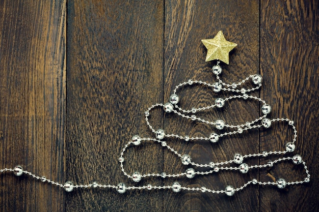 Vue de dessus de l&#39;arrière-plan de Noël. Arbre de Noël par des décorations de Noël, une étoile d&#39;or de Noël et une corbeille à bijoux sur fond de table en bois avec copie.