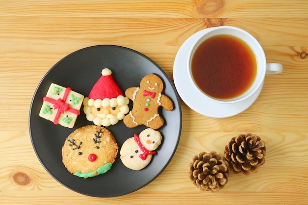 Vue de dessus d'une assiette de biscuits de Noël avec une tasse de thé chaud sur table en bois